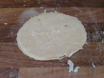 Runder Teigfladen auf einer Arbeitsfläche