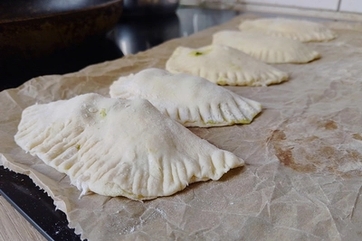 Mehrere rohe Bolani auf einem Backpapier