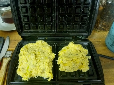 Roher Kartoffelteig auf einem geölten Waffeleisen