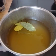 Flüssigkeit aus Apfelessig und Wasser, mit Nelken und Lorbeerenblättern