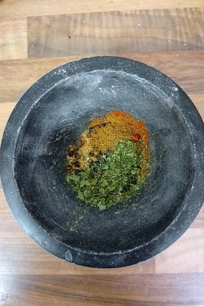 Mörser mit unterschiedlichen Gewürzen, die noch nicht zermahlen sind