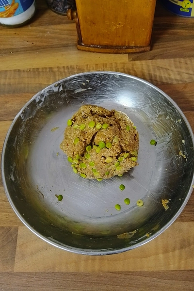 Vermischtes Seitan, mit Haferresten und Gewürzen, die zu einem Klumpen verknetet wurden, welch in einer metallischen Schale liegt